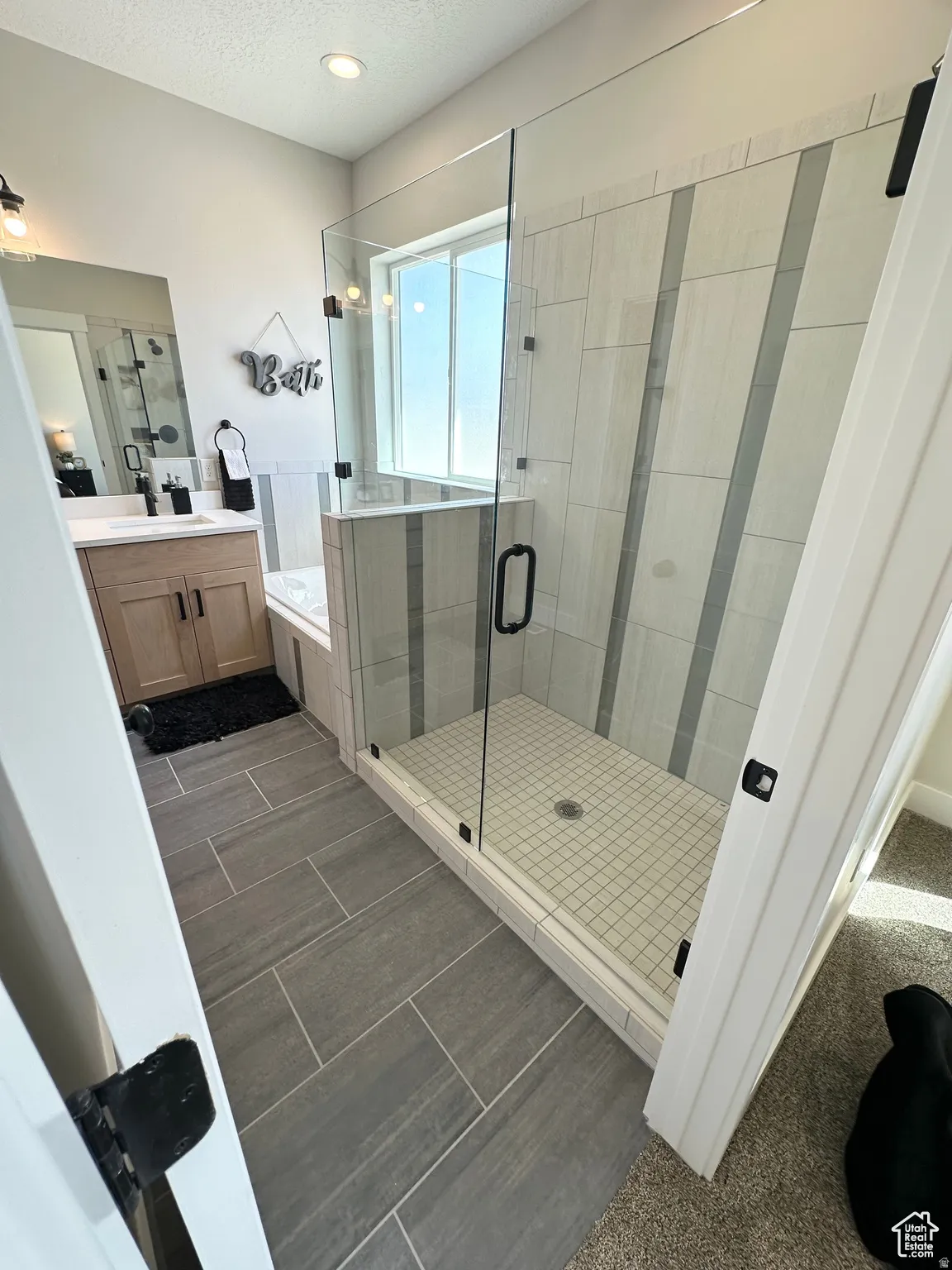 Full bath with a garden tub, vanity, a shower stall, and a textured ceiling