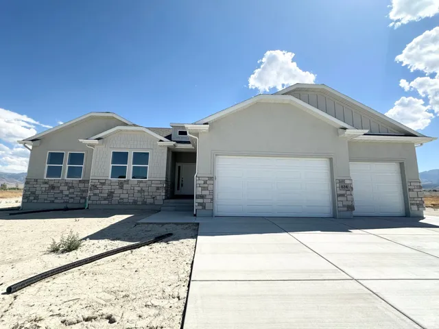 Craftsman-style house with stone siding, a garage, and concrete driveway