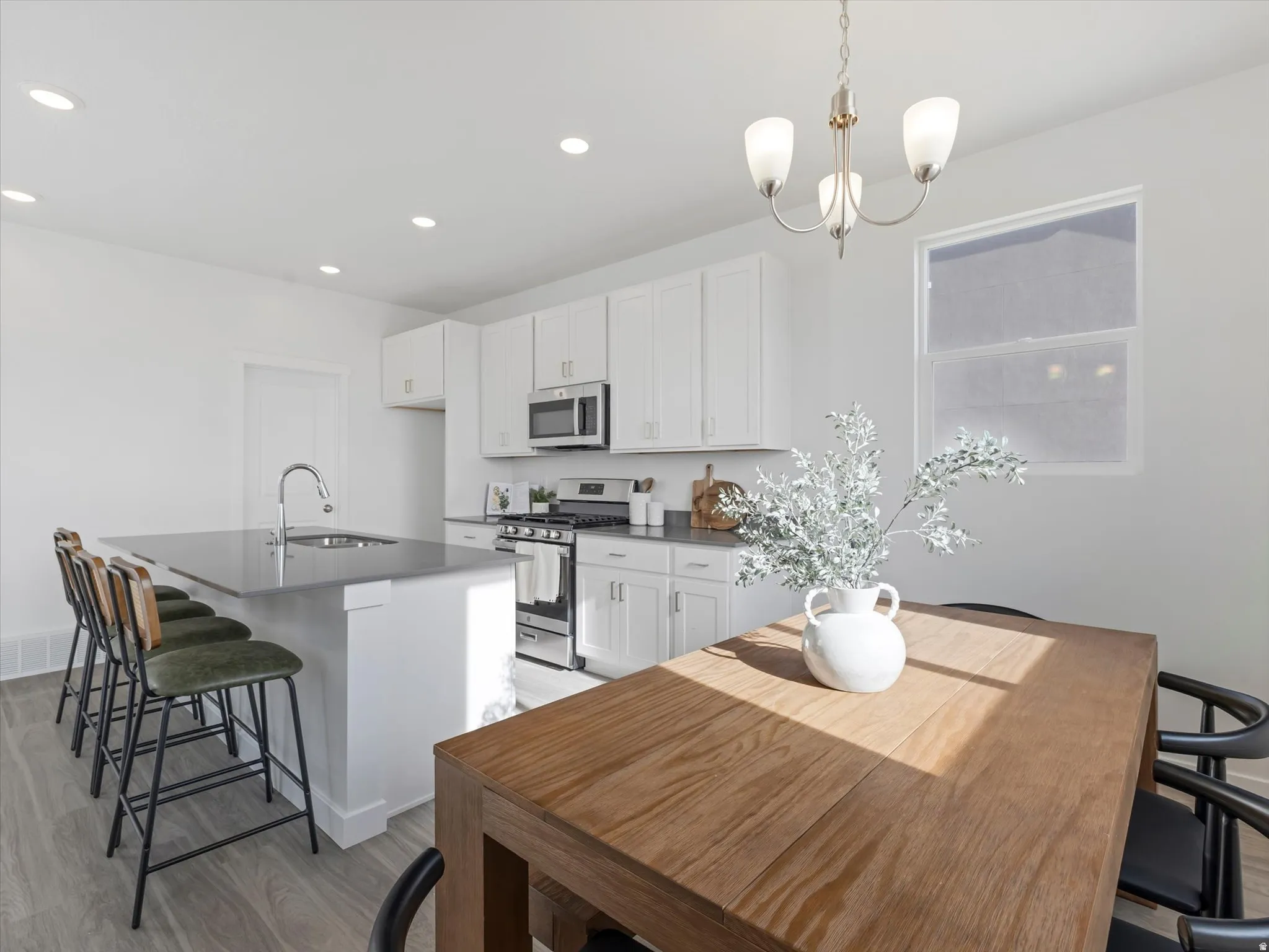 Kitchen featuring a breakfast bar, stainless steel appliances, and white cabinetry