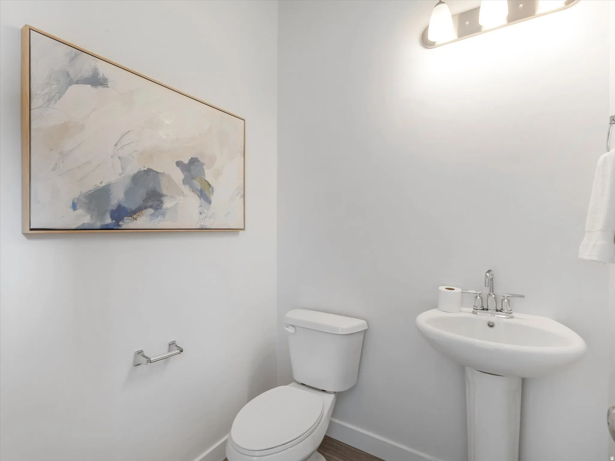 Half bathroom with toilet and baseboards