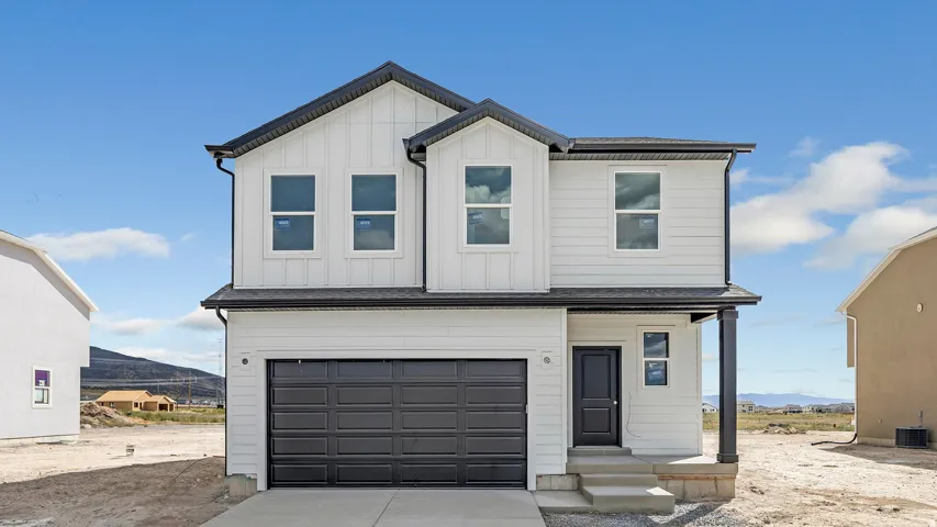 View of front of house with a mountain view, an attached garage, concrete driveway, board and batten siding, and a porch