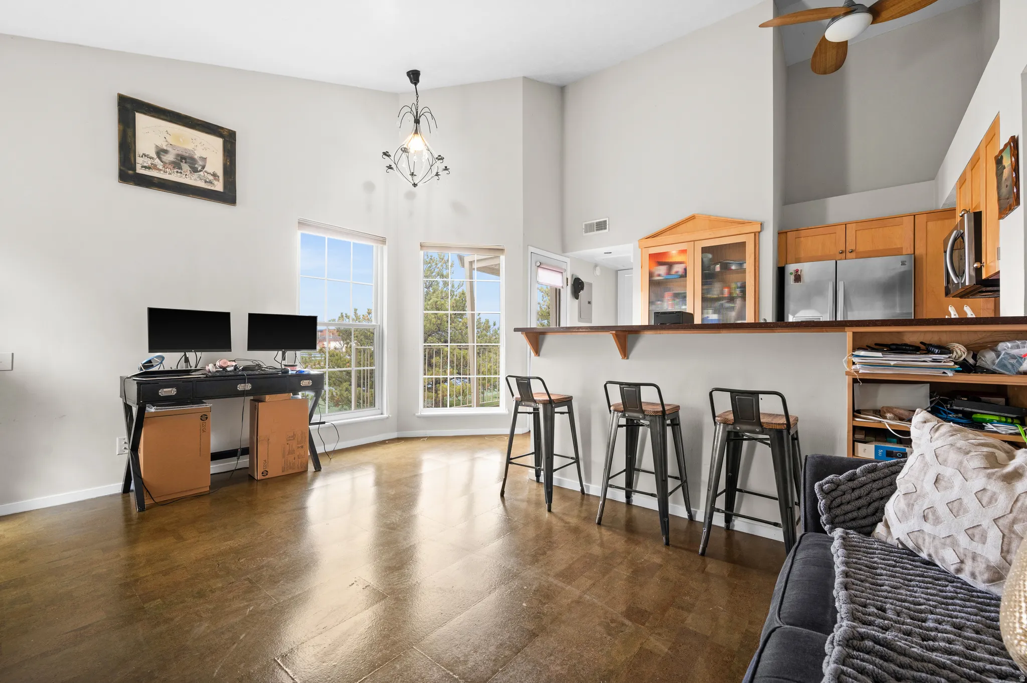 Kitchen featuring a breakfast bar area, a high ceiling, stainless steel appliances, pendant lighting, and ceiling fan