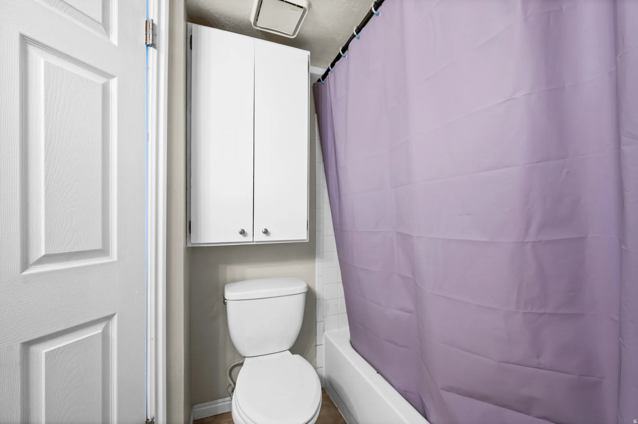 Full bath featuring toilet and shower / bath combo