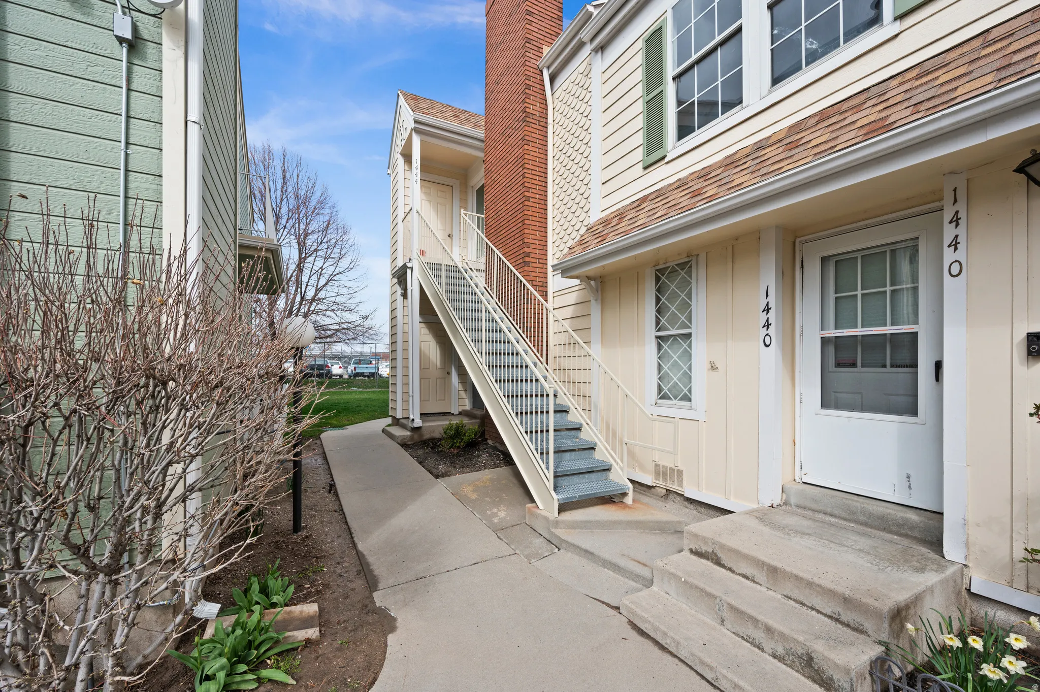 View of exterior entry with roof with shingles, a chimney, and board and batten siding