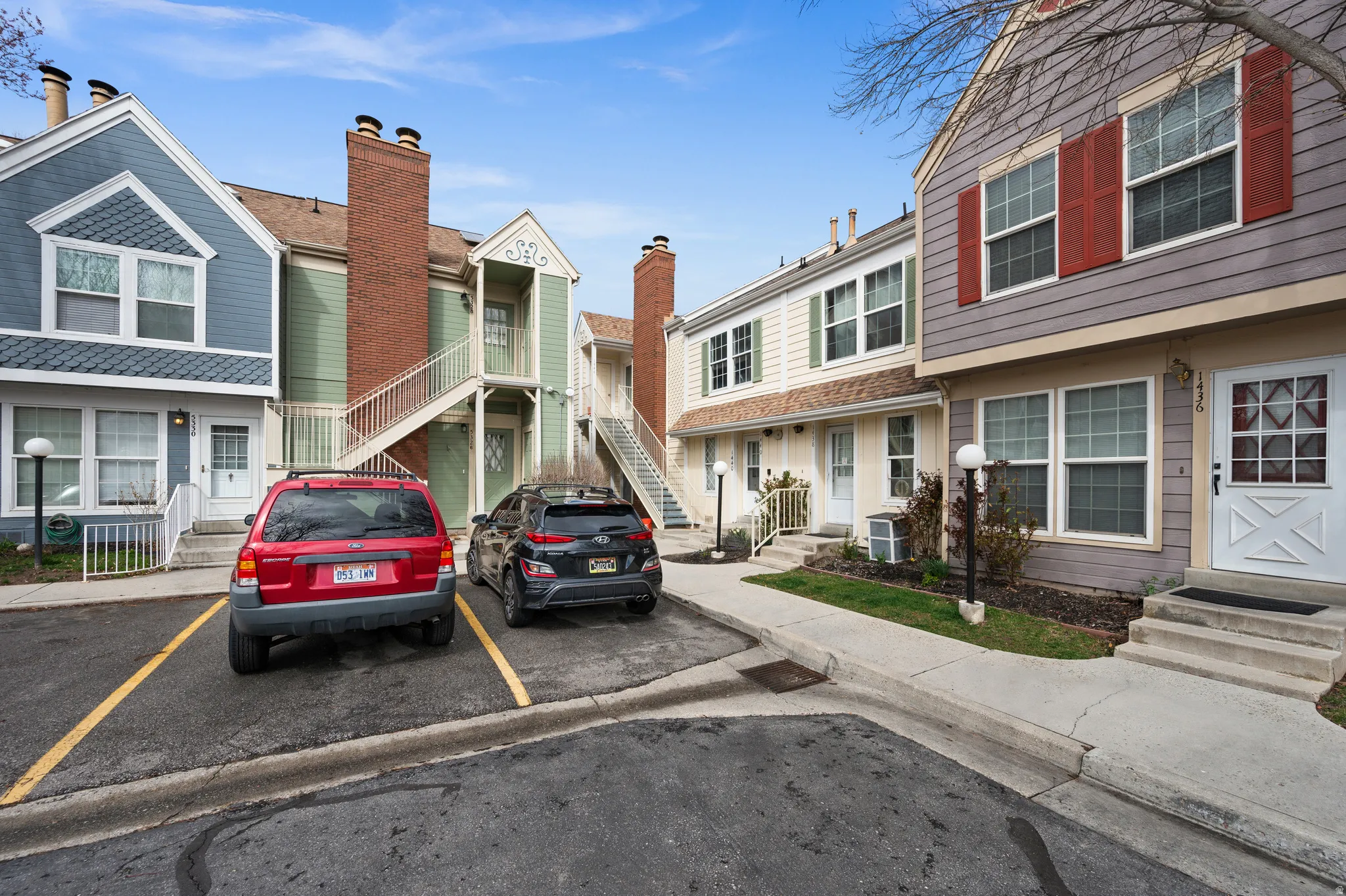 View of front facade featuring uncovered parking and a chimney