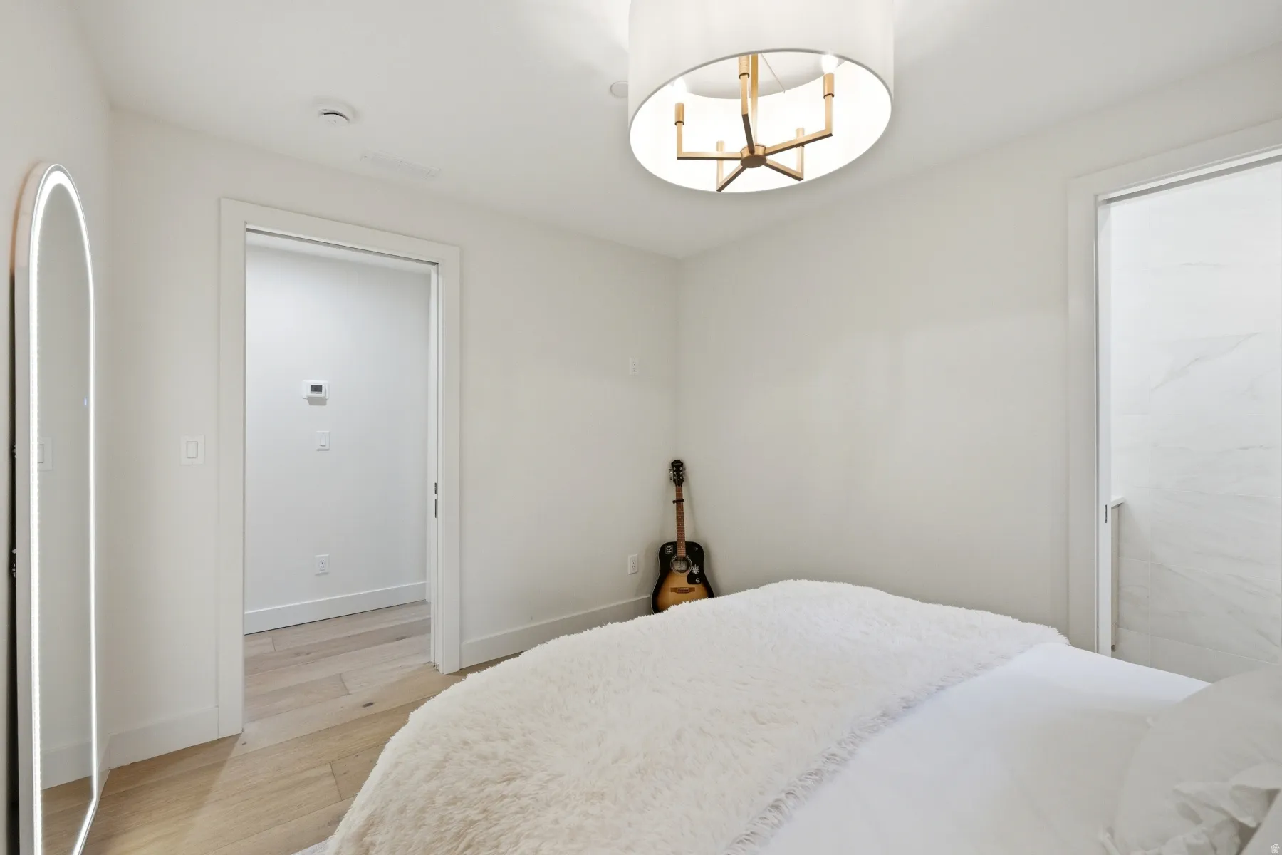 Bedroom with light wood-type flooring and hanging lights