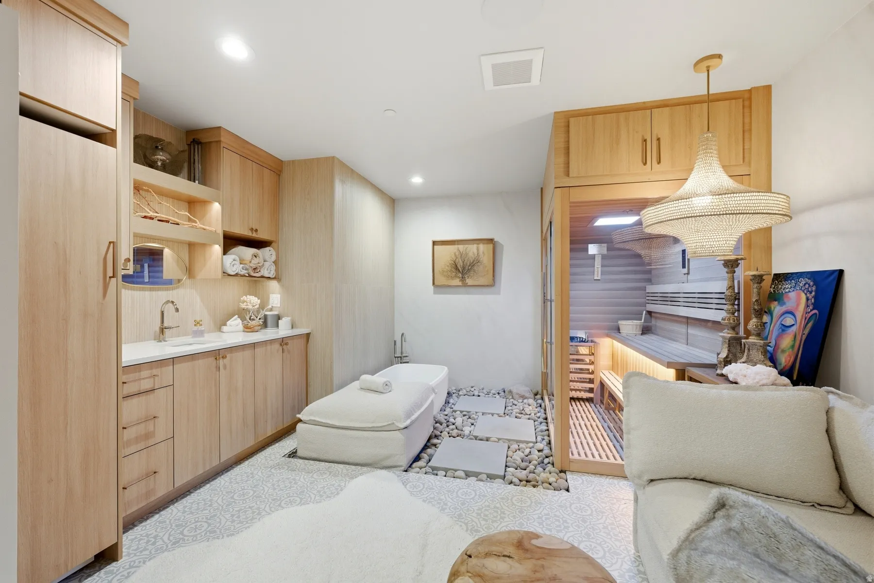 Kitchen with light wood finish cabinetry, open shelves, light countertops, decorative light fixtures, and modern cabinets