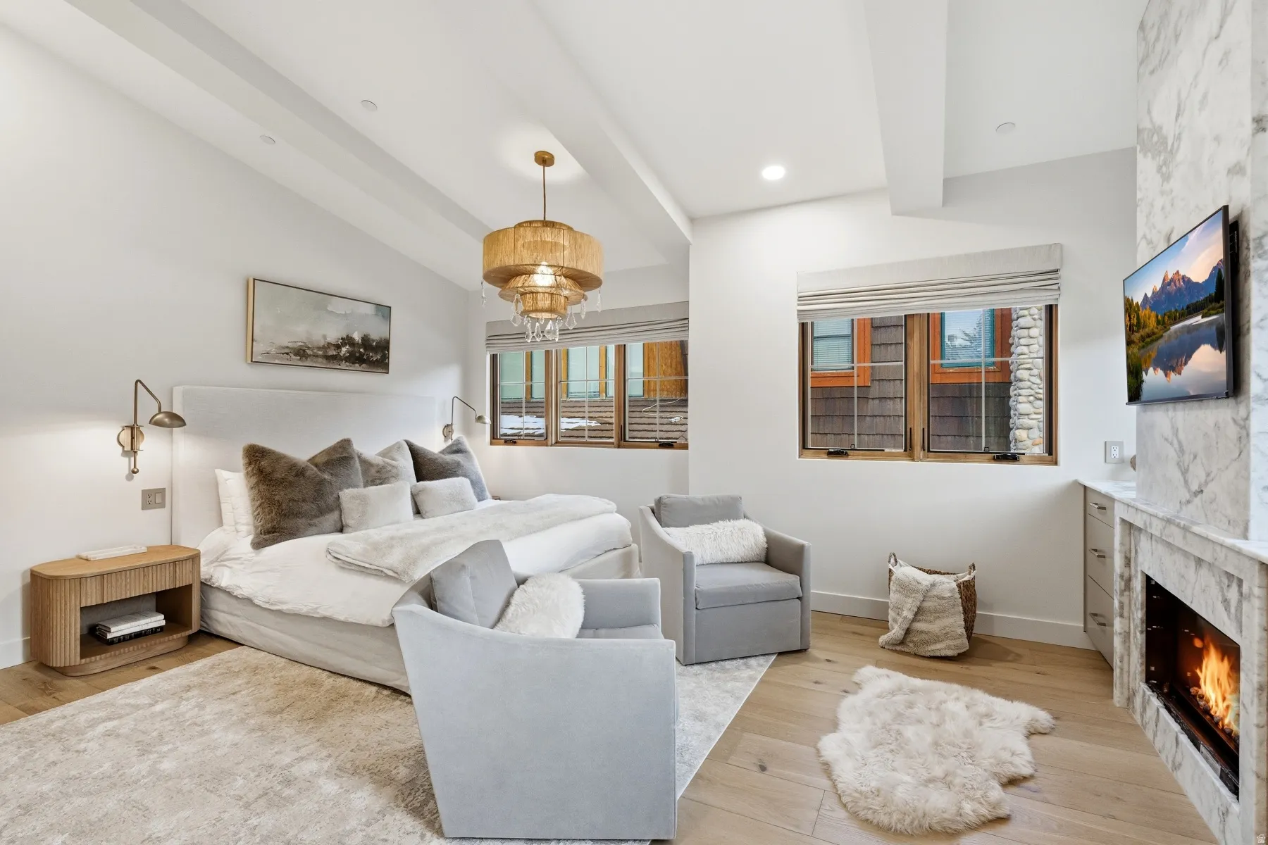 Bedroom with beam ceiling, light wood finished floors, a high end fireplace, and recessed lighting