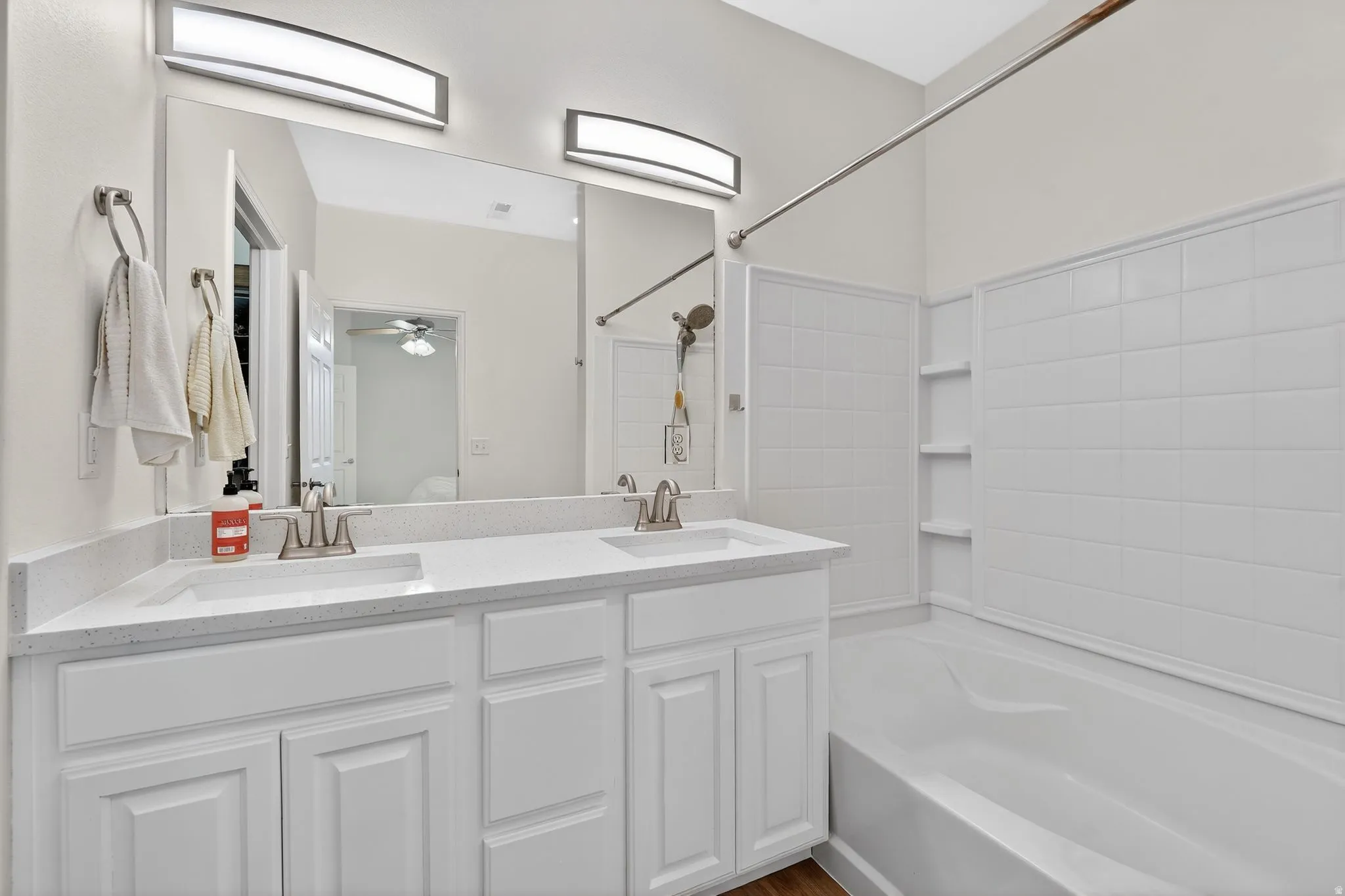 Full bath featuring double vanity, shower / bathtub combination, and a ceiling fan