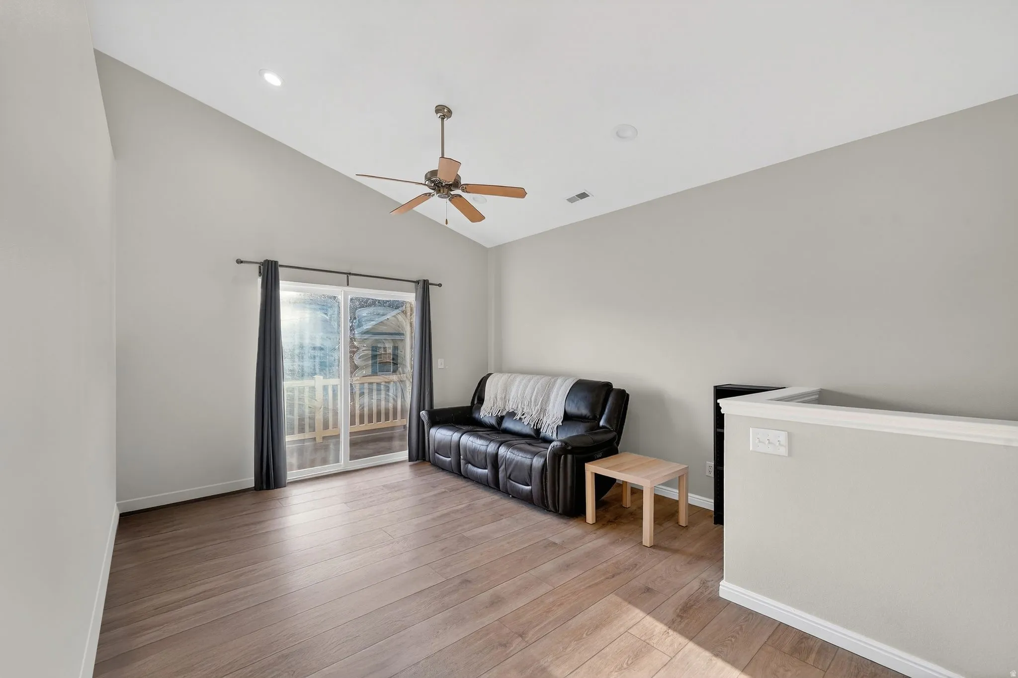 Living area with vaulted ceiling, light wood-style floors, ceiling fan, and recessed lighting