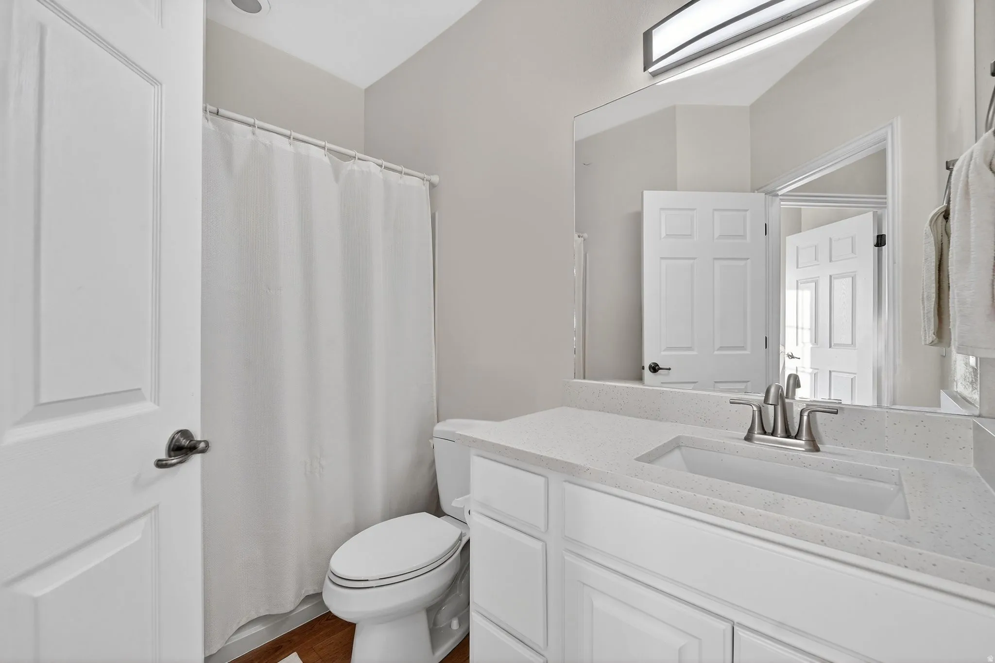 Full bathroom featuring curtained shower and vanity
