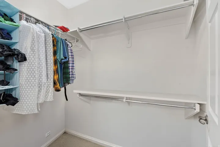 Walk in closet featuring light colored carpet