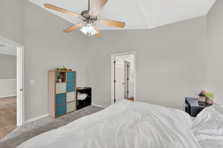 Bedroom featuring lofted ceiling, light carpet, and a ceiling fan