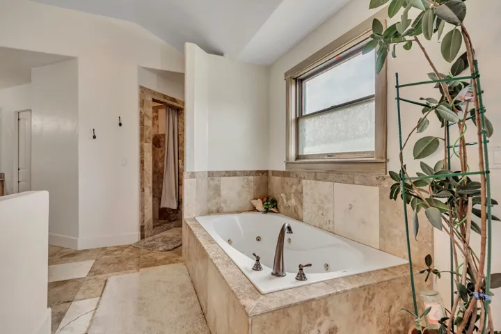 Full bath featuring a jetted tub and a stall shower