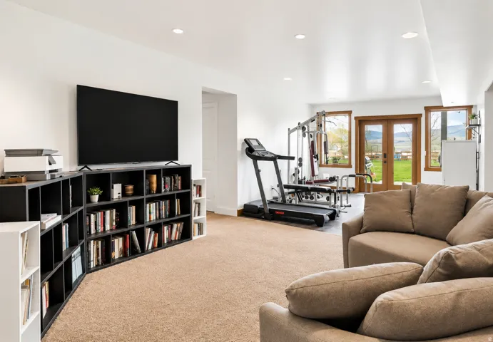Spacious room featuring neutral carpeting, recessed lighting, and a large built-in shelving unit