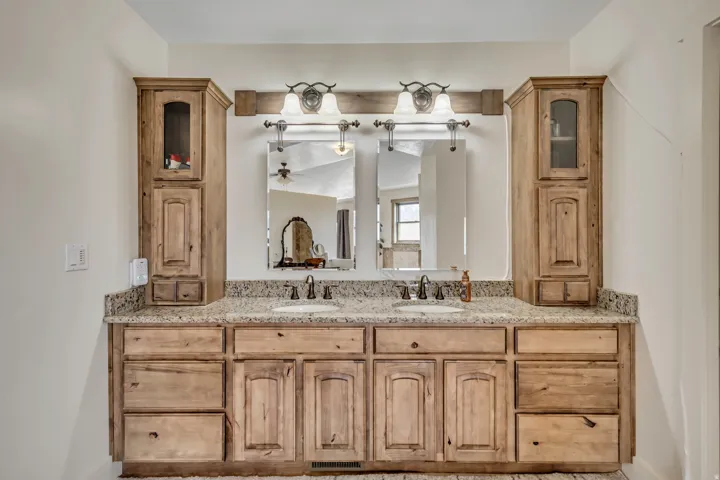 Full bathroom with double vanity and a ceiling fan