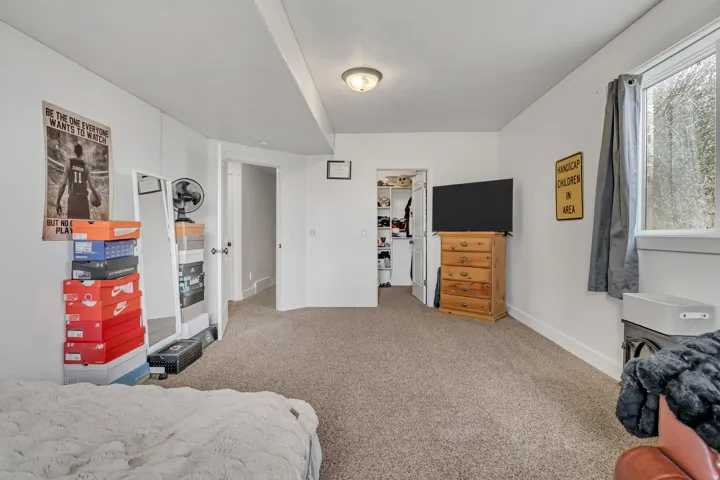 Bedroom with a walk in closet and light colored carpet