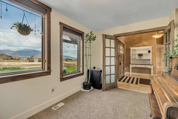 Living area featuring a mountain view, light colored carpet, and french doors