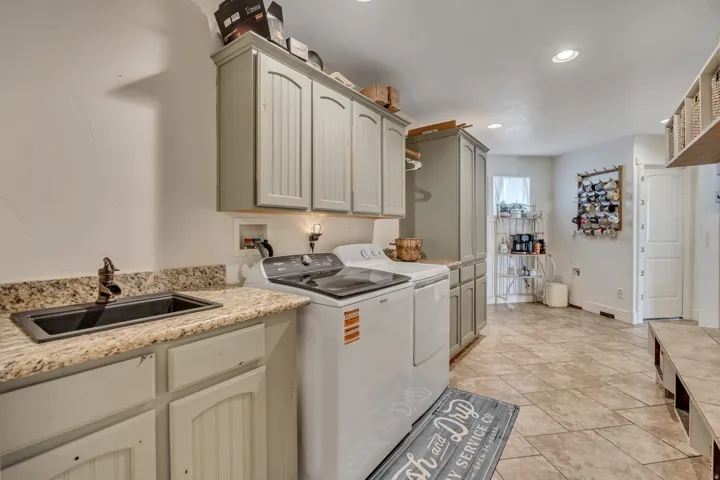 Laundry area with cabinet space, washing machine and clothes dryer, and recessed lighting