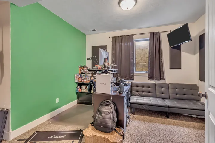 Living area featuring baseboards and a desk