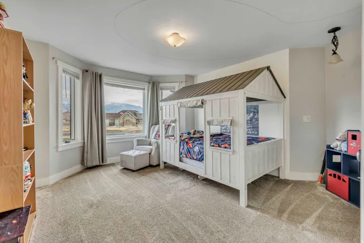 Bedroom featuring light carpet and baseboards