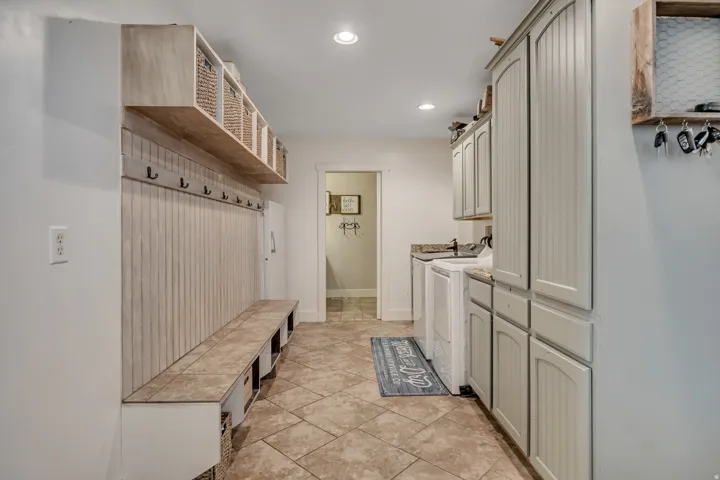 Laundry room with cabinet space, recessed lighting, washing machine and clothes dryer, and light tile patterned floors