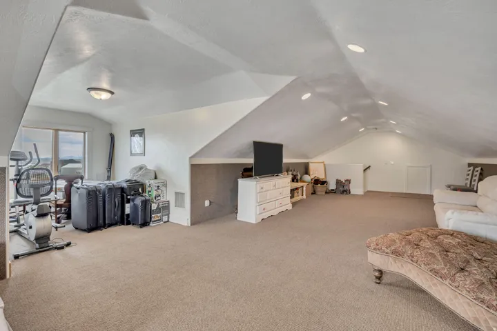 Additional living space featuring light colored carpet and a textured ceiling