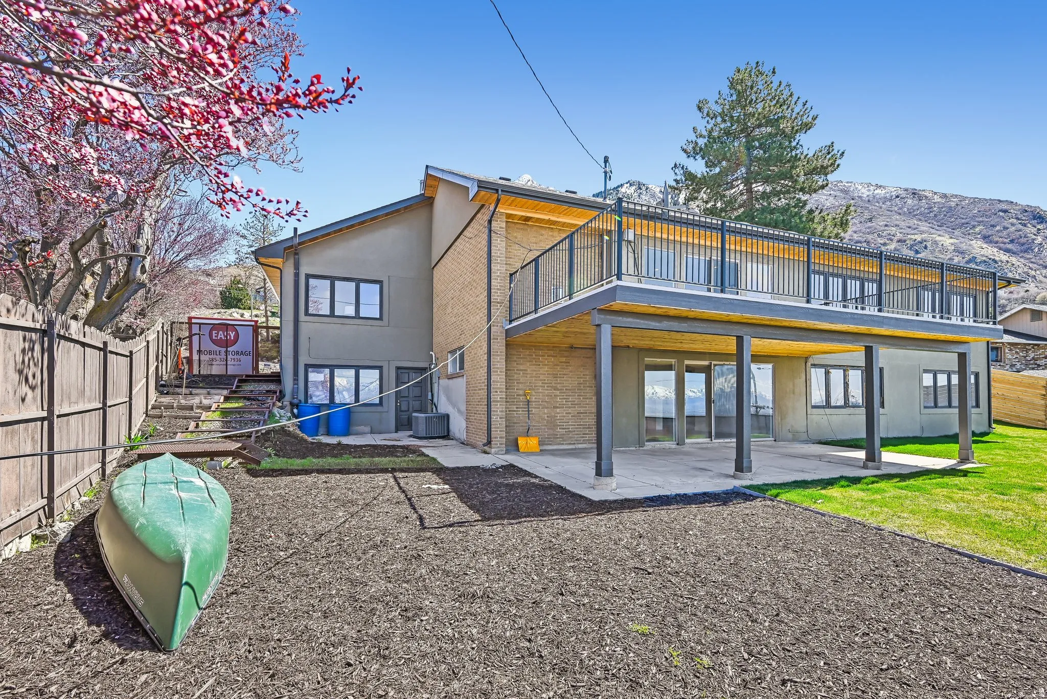Back of house with a patio, brick siding, and stucco siding