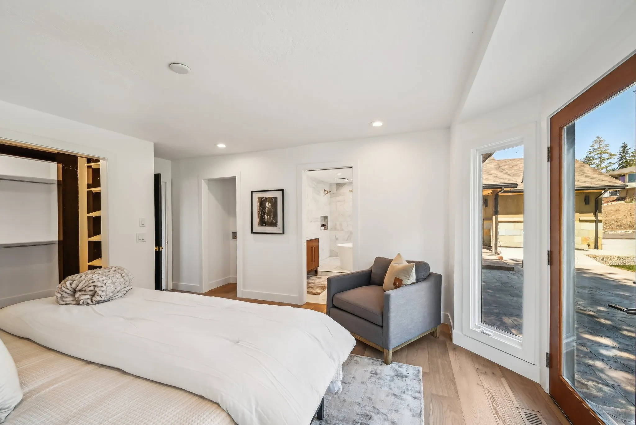 Bedroom featuring access to outside, light wood finished floors, recessed lighting, and a walk in closet