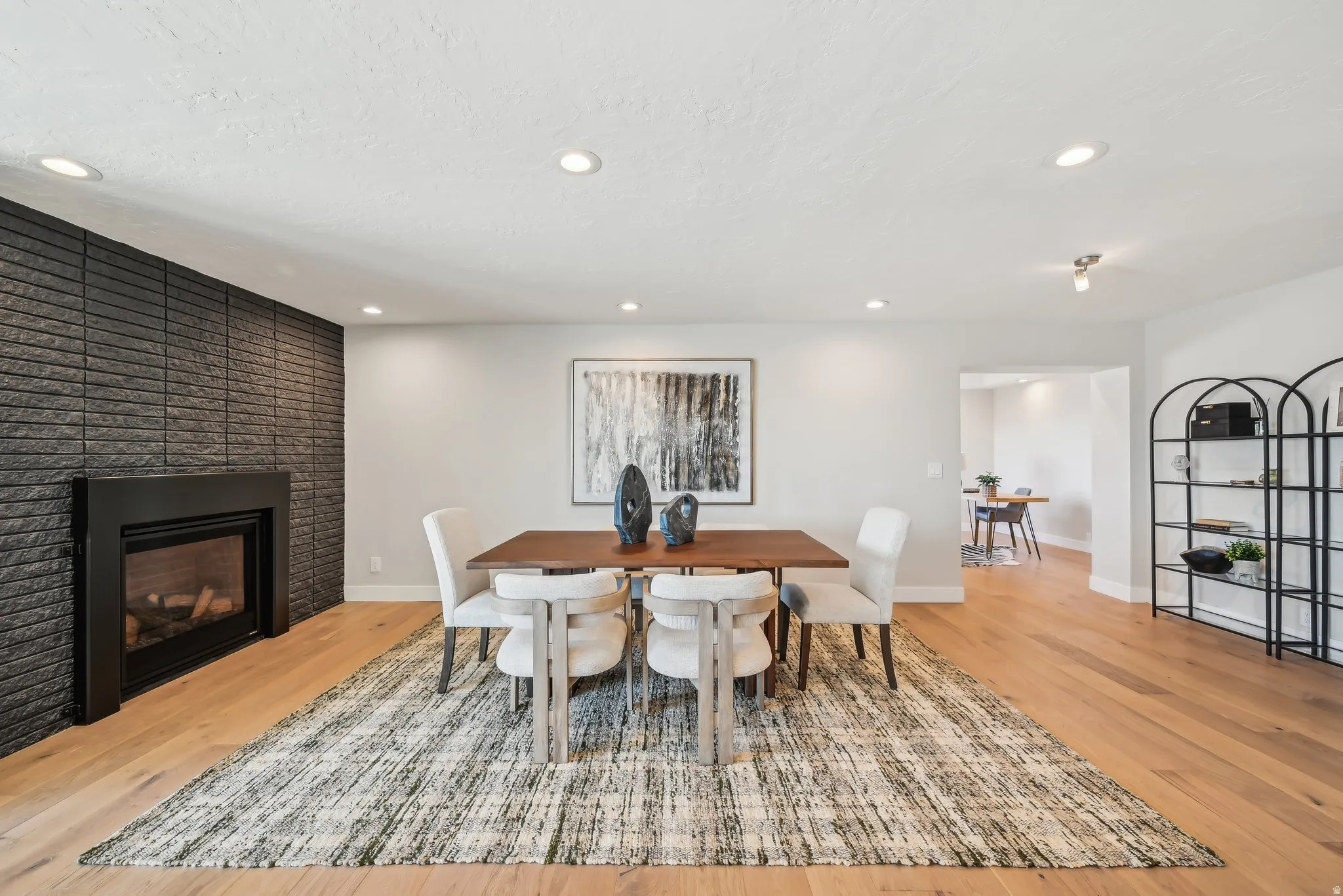 Dining space featuring light wood-type flooring, a fireplace, and recessed lighting