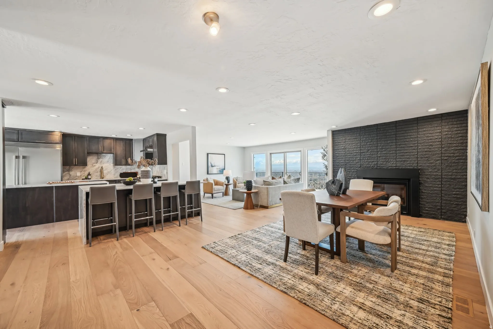 Dining space featuring light wood finished floors, a large fireplace, and recessed lighting
