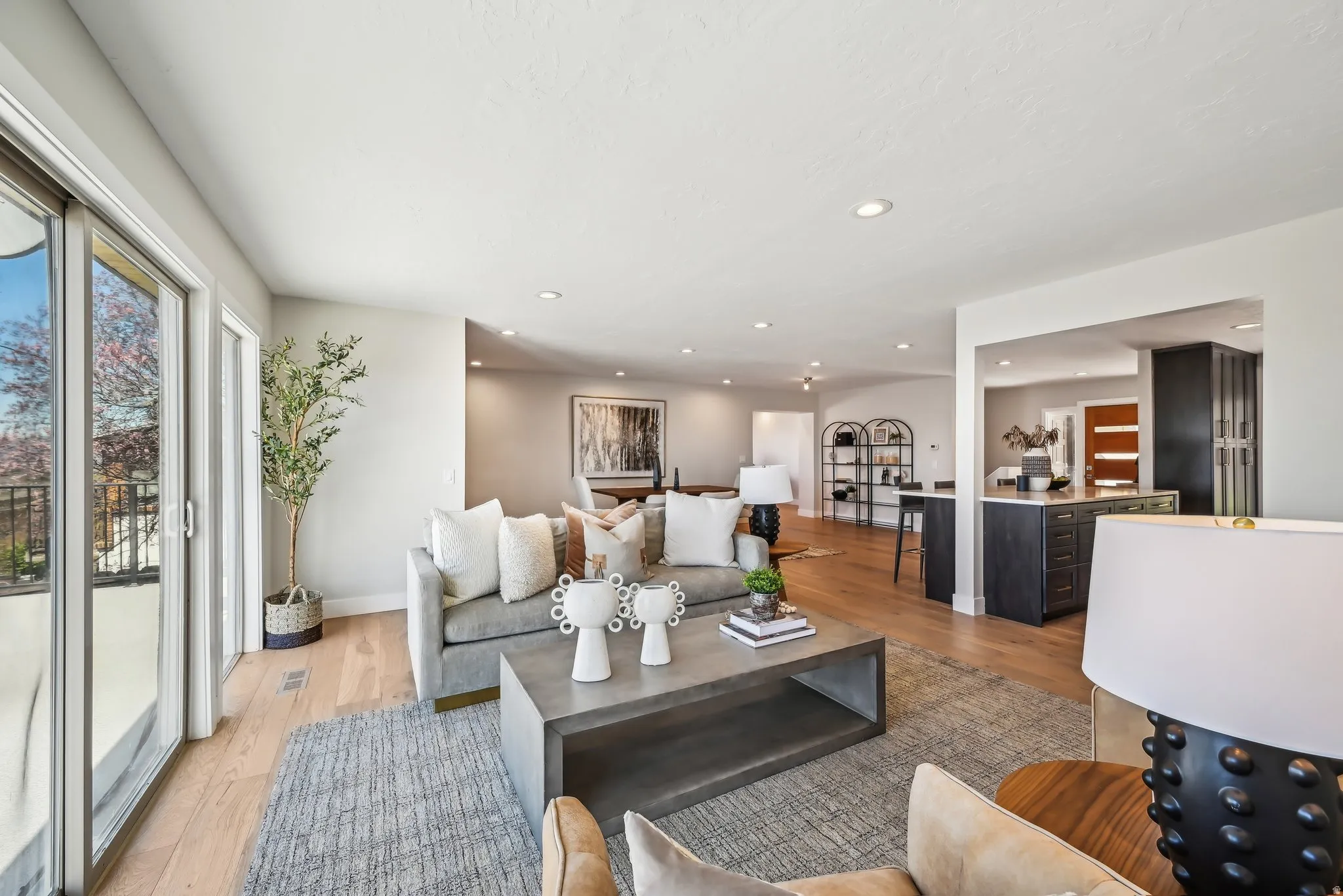 Living area with light wood-type flooring and recessed lighting