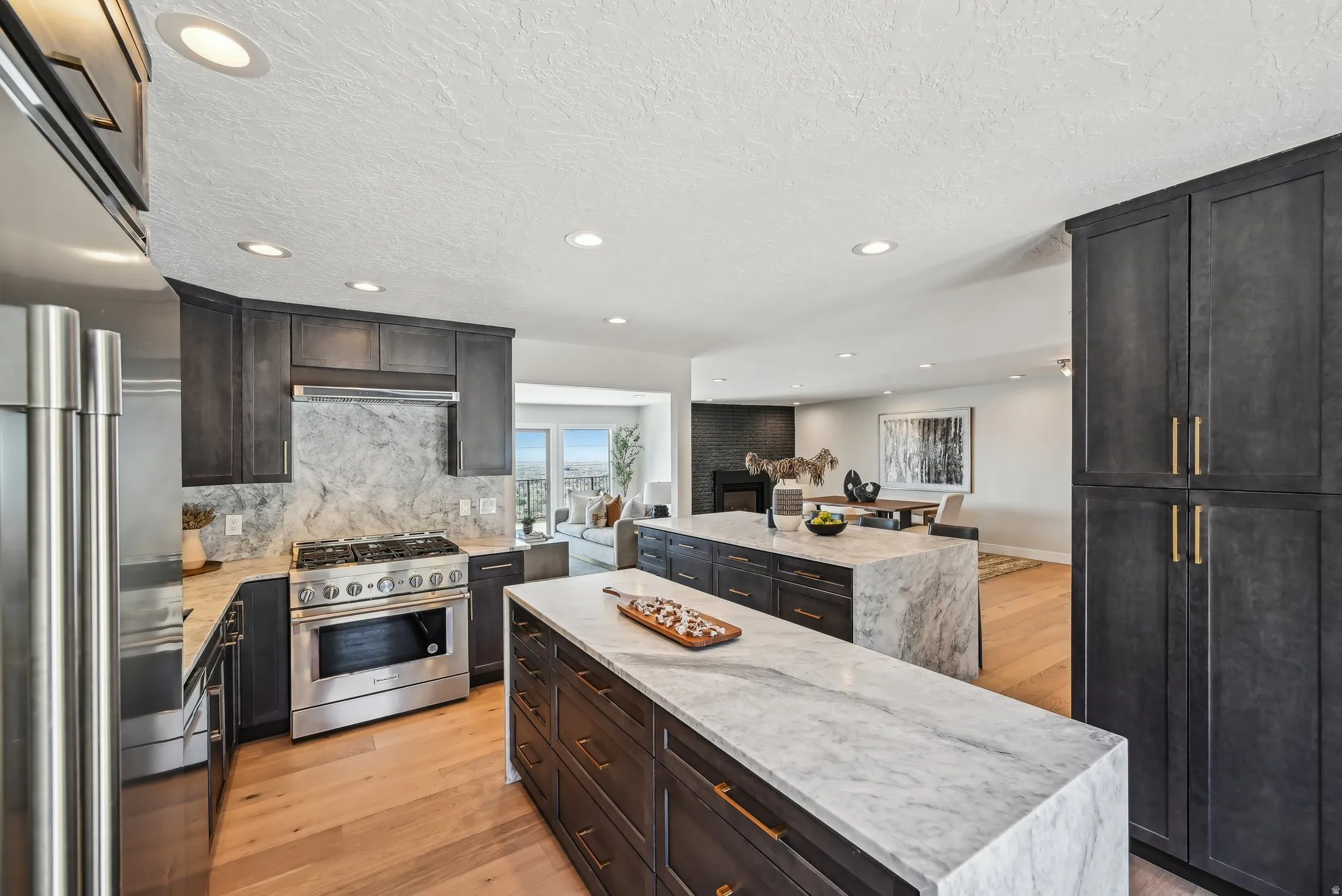 Kitchen featuring a kitchen island, high end appliances, light wood finished floors, light stone countertops, and decorative backsplash