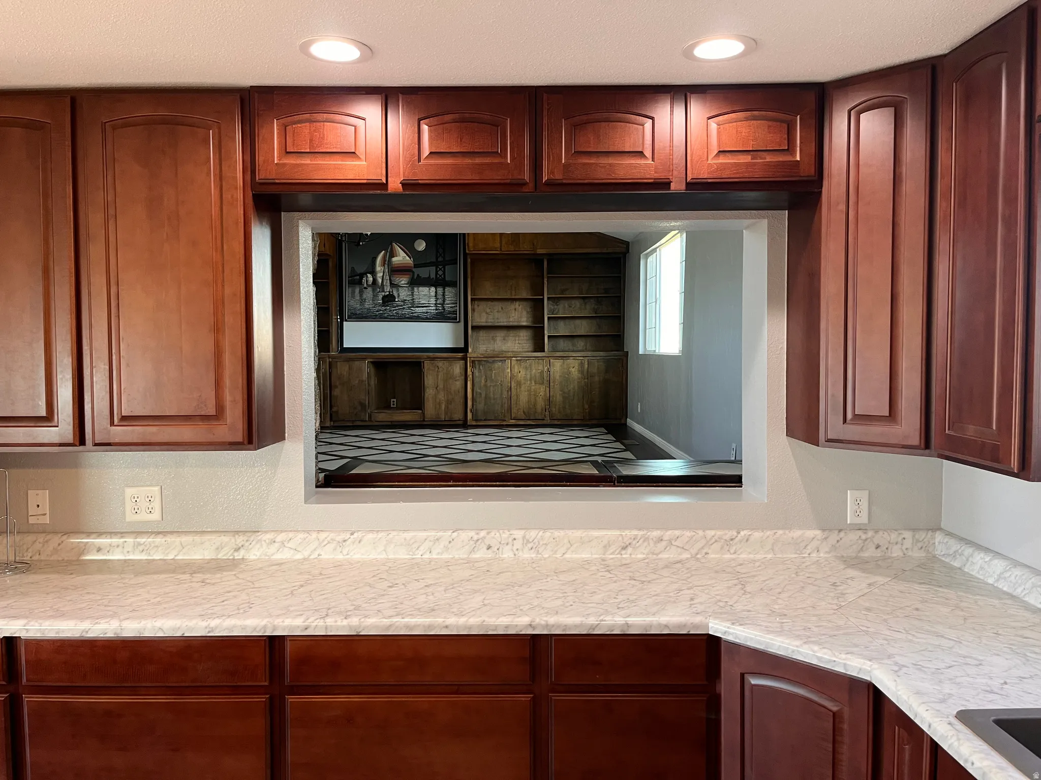 Kitchen featuring light countertops and recessed lighting large serving window to the theatre room
