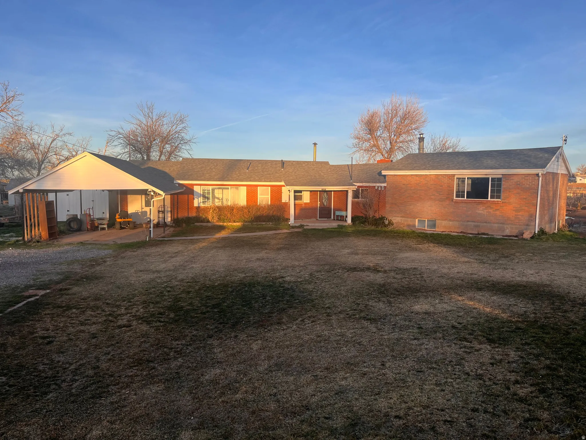Ranch-style home featuring a patio area, brick siding, and a front yard