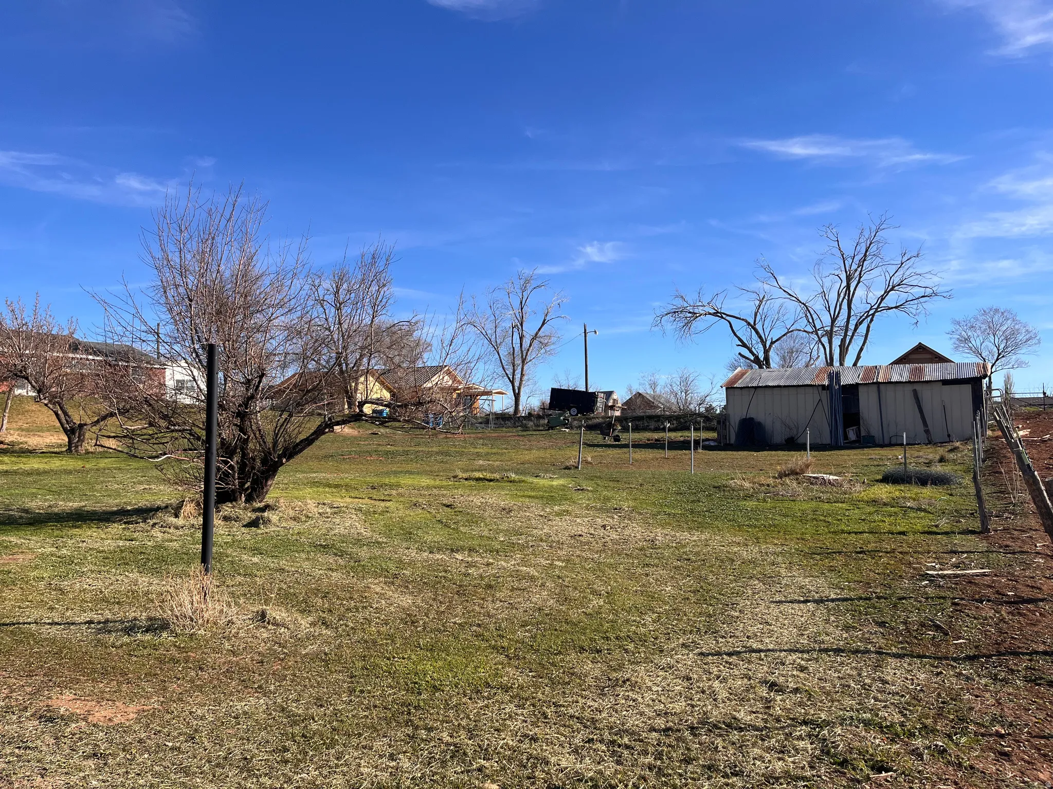View of grassy yard featuring an outdoor structure and a pole building
