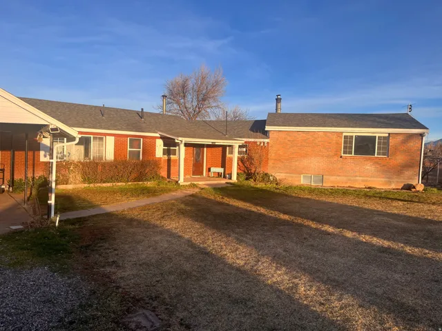 Single story home with brick siding, a front lawn, and roof with shingles