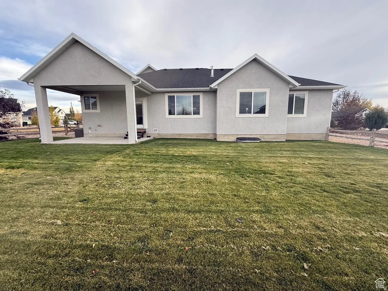 Rear view of house with stucco siding and a patio area