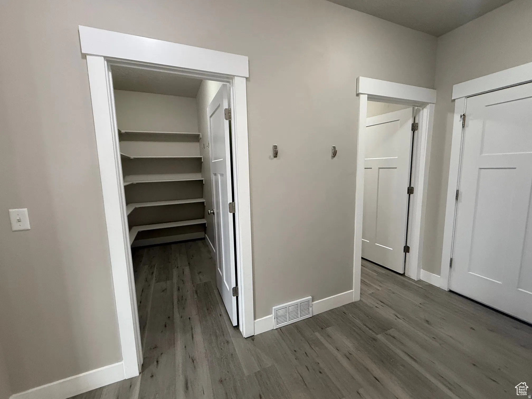 Hallway with dark wood-style floors and baseboards