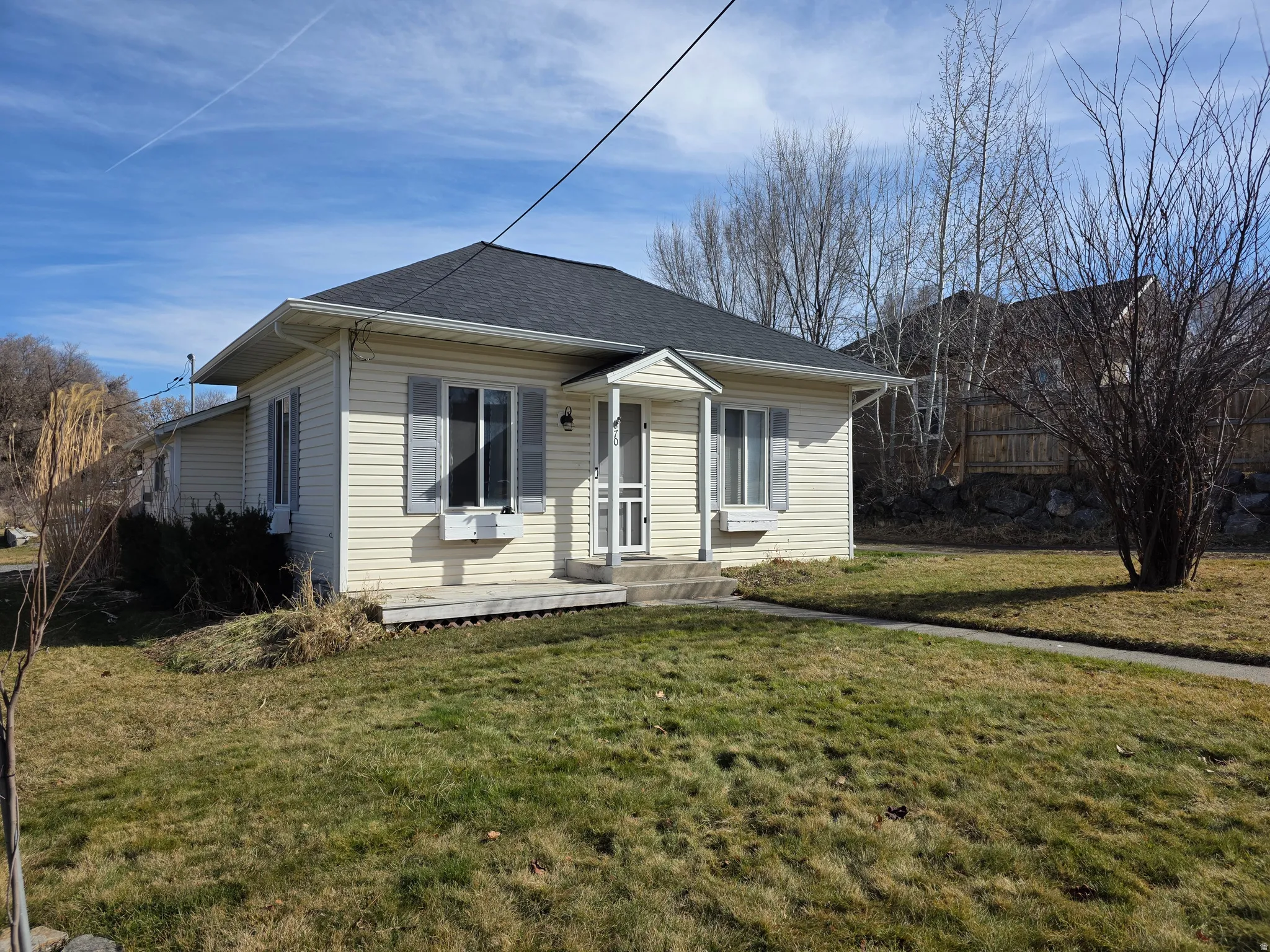 View of front of property with a front yard and a shingled roof