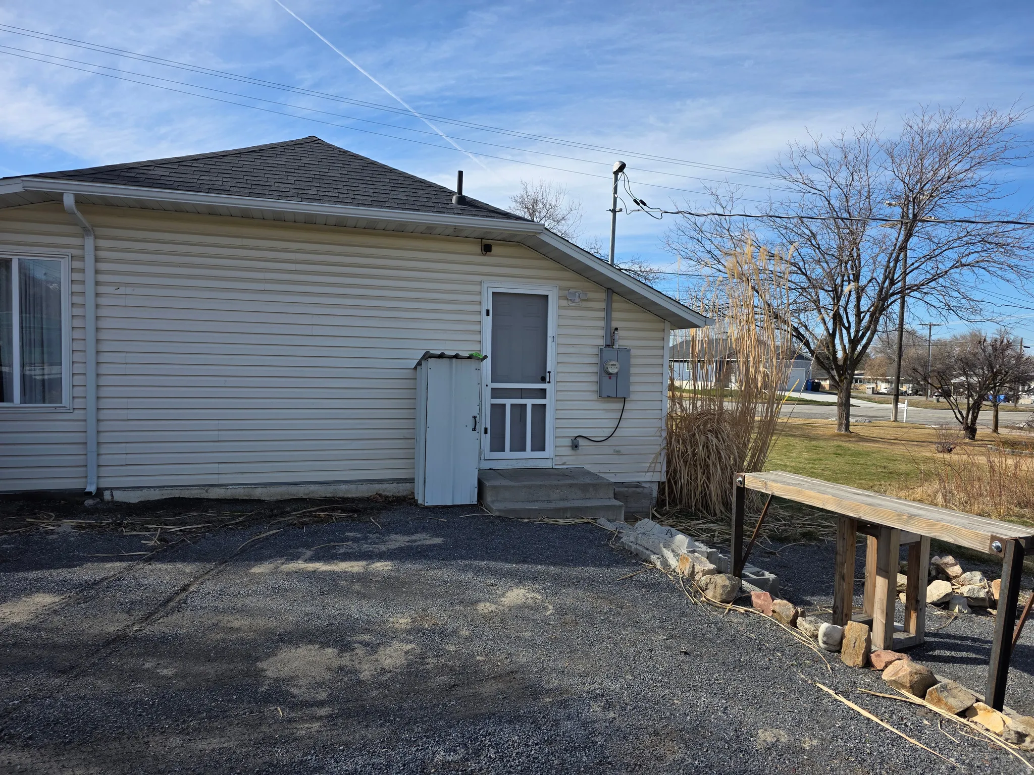 Back of property with a shingled roof and entry steps