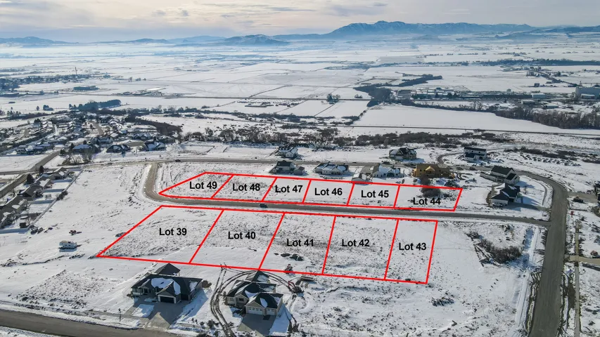 Snowy aerial view with property boundaries highlighted and a mountain view