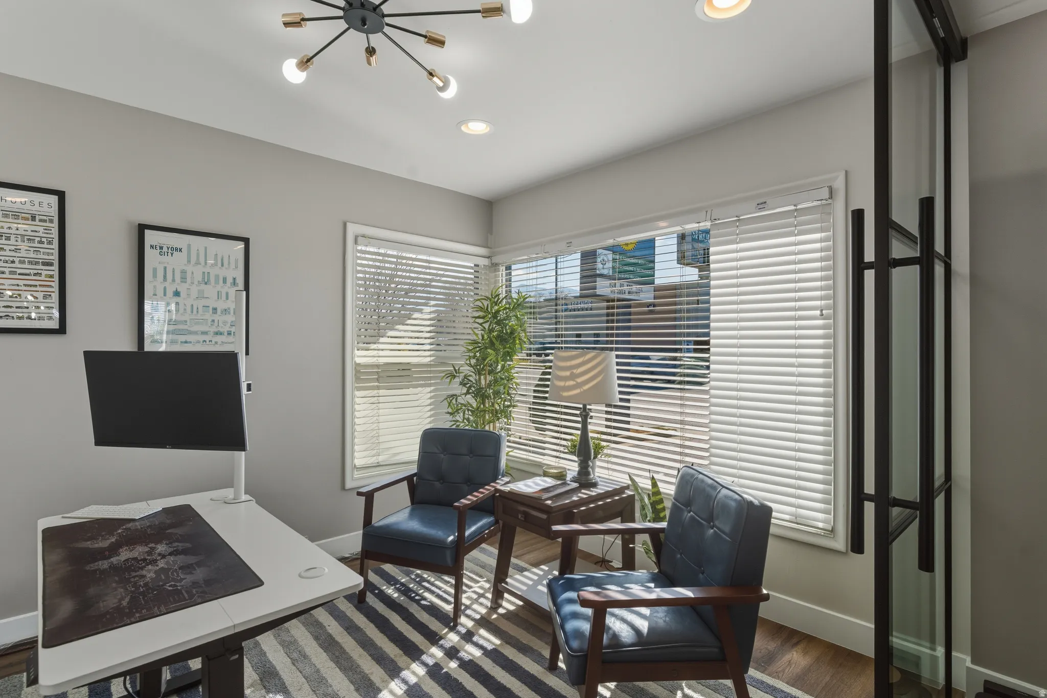 Office with dark wood-style flooring and suspended lighting