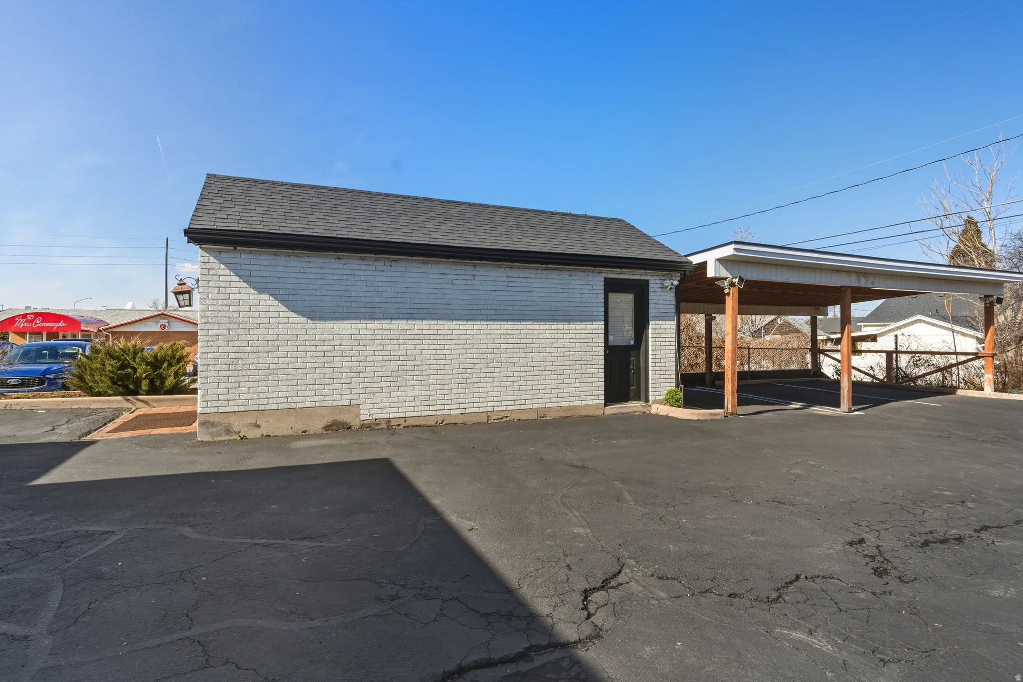 View of home's exterior with roof with shingles and brick siding