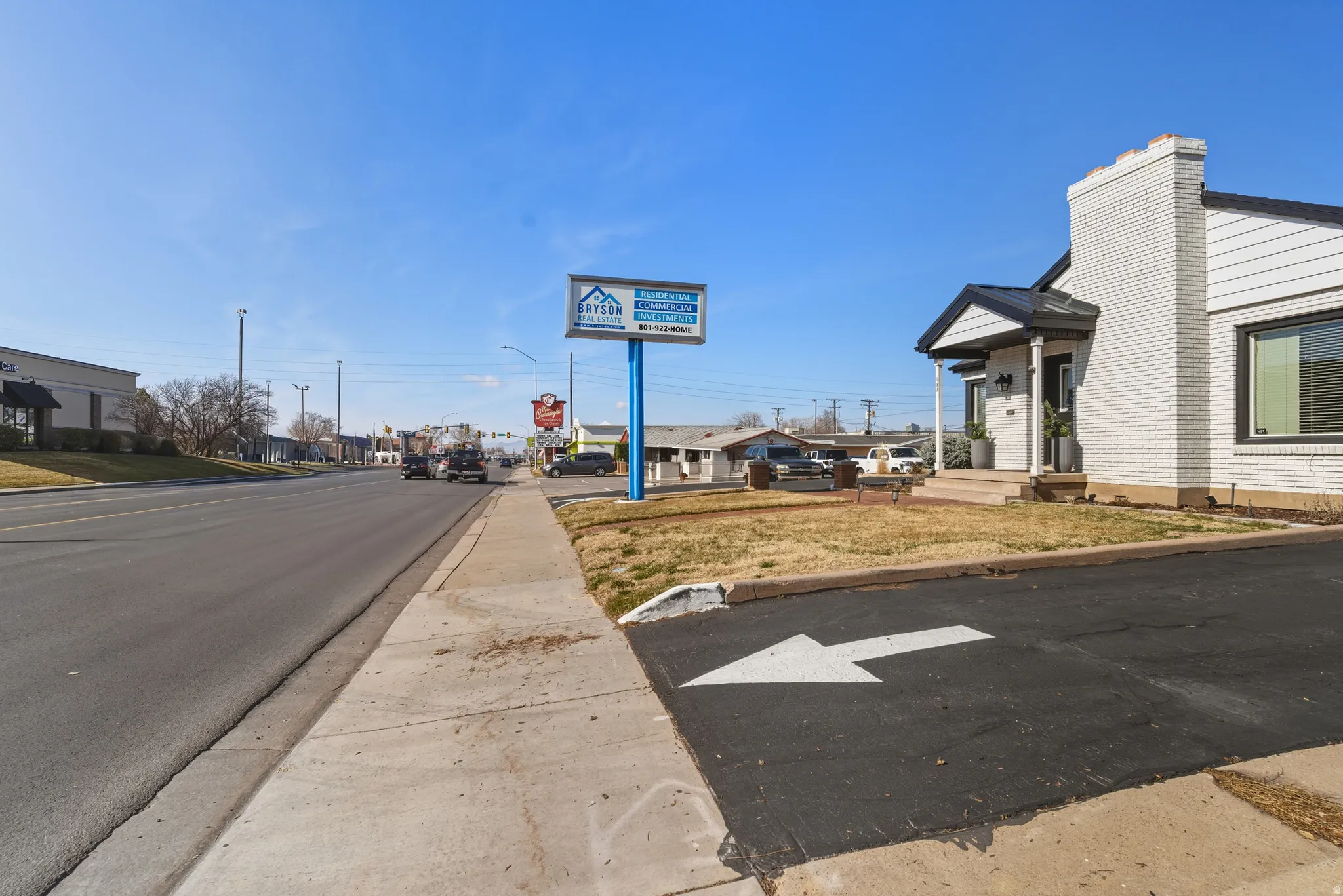 View of asphalt road with a residential view, curbs, street lighting, and sidewalks