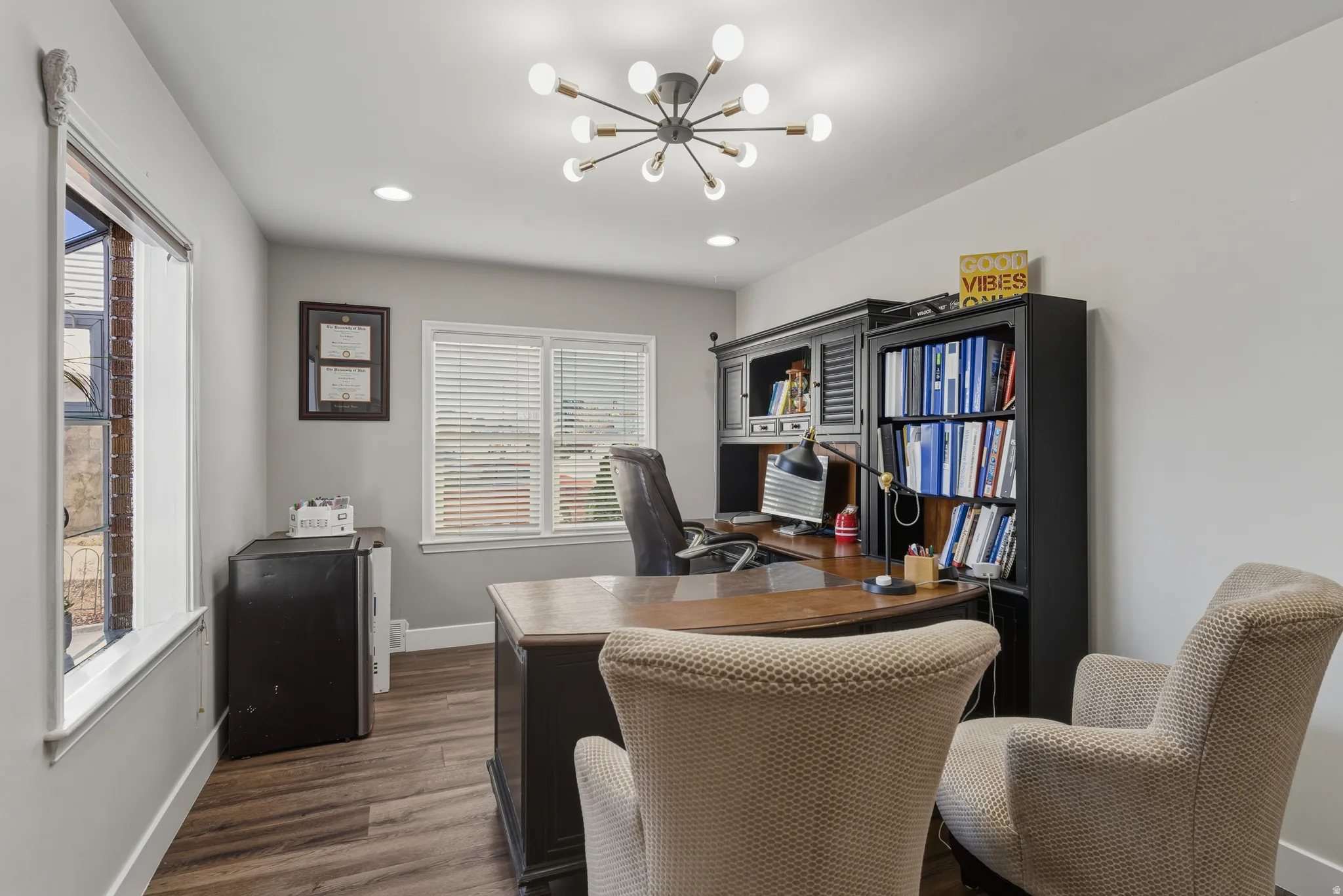 Office area with dark wood finished floors and suspended lighting