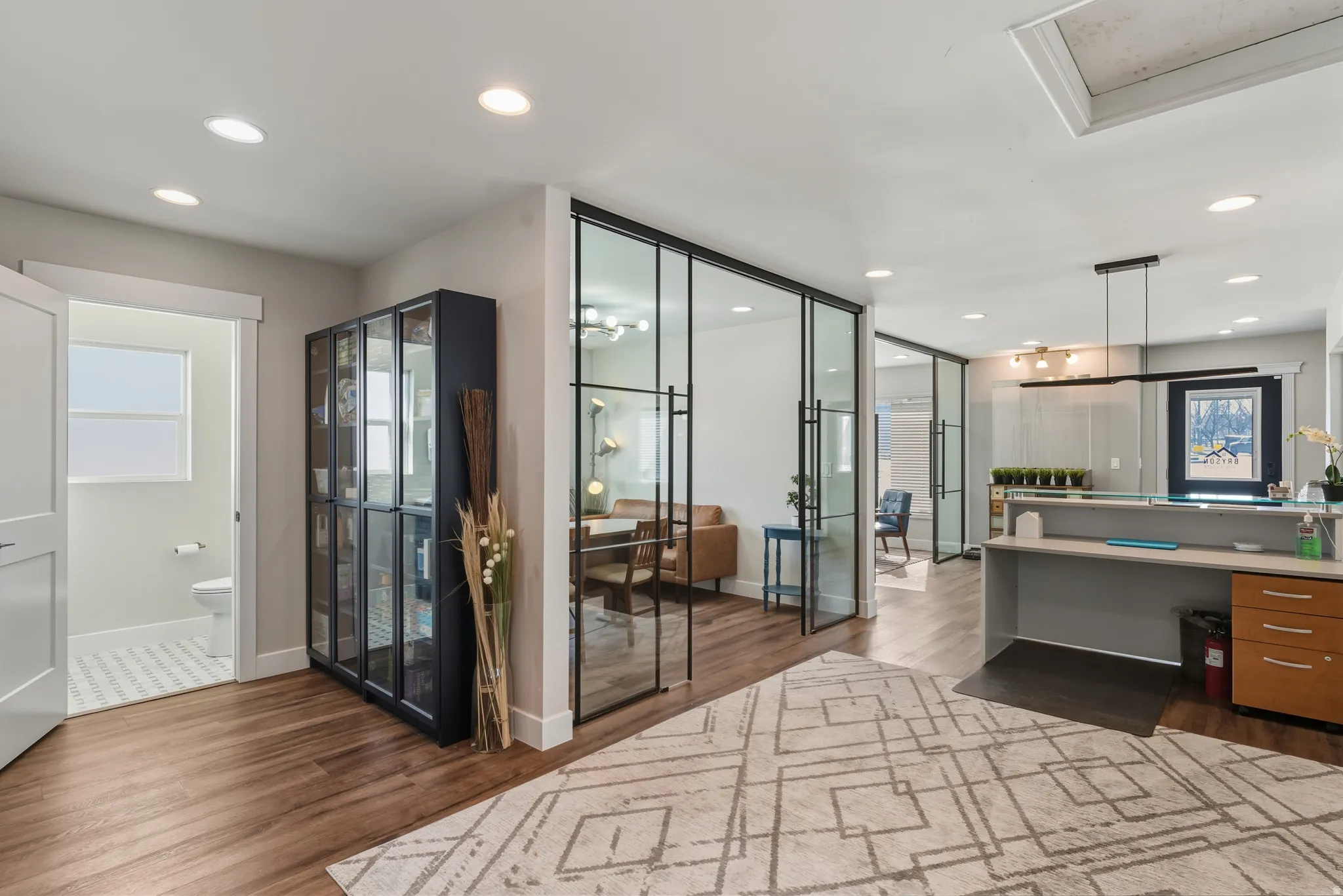 Home office with dark wood-style flooring and recessed lighting