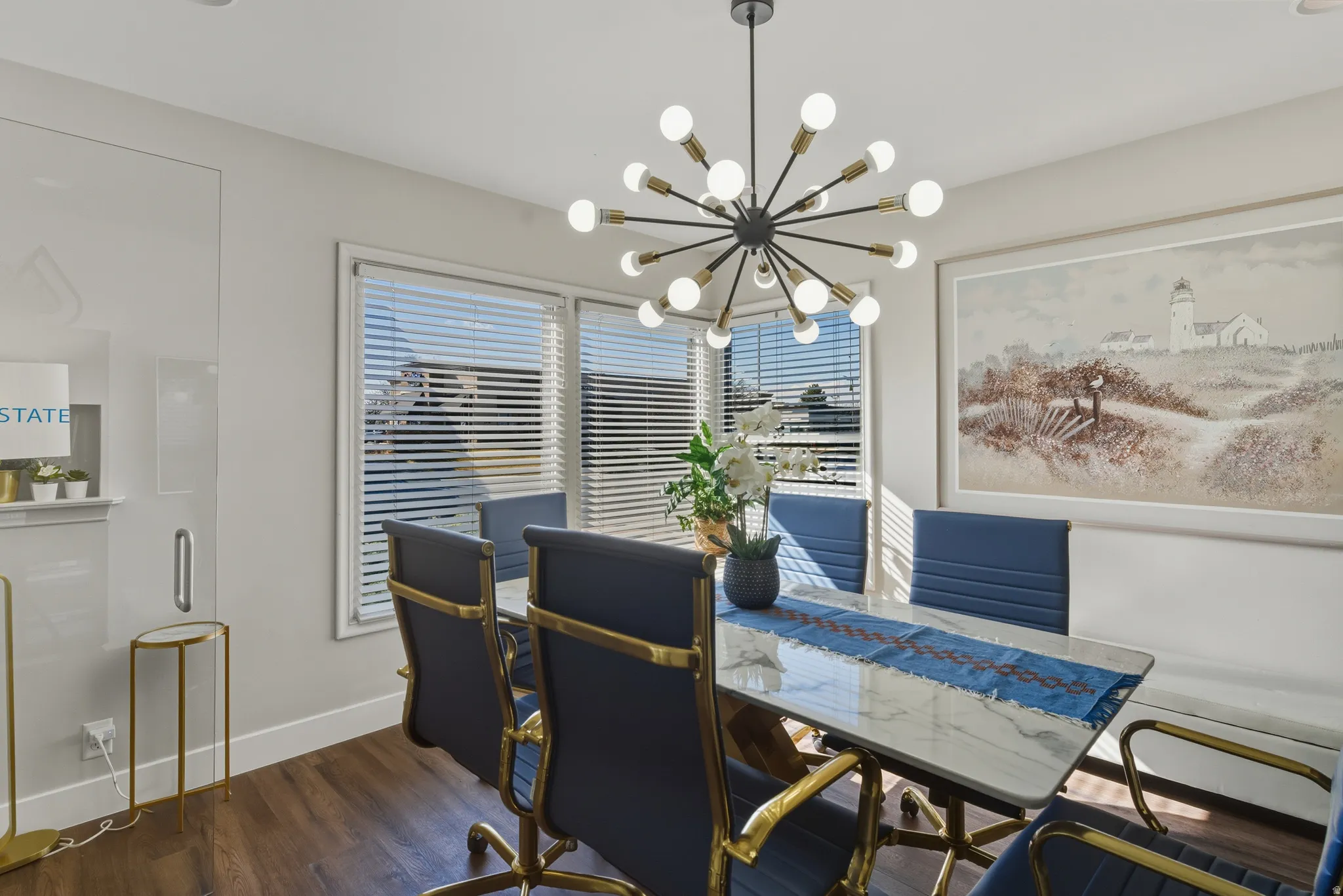 Dining room with dark wood-style flooring and hanging lights