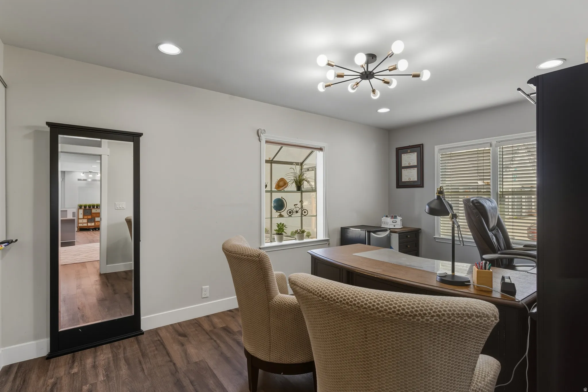 Office area with dark wood-type flooring and hanging lights