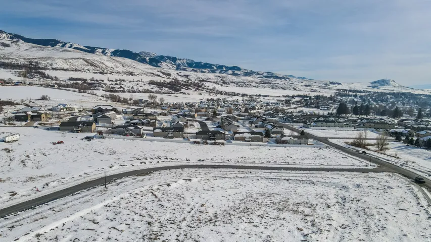 Snowy aerial view featuring a mountain view and a residential view